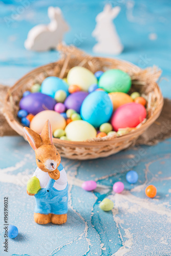 Cute decorative Easter bunny and colorful easter eggs on a blue background