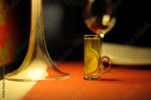 Shot of Becherovka herbal liqueur with a lemon slice on a restaurant table