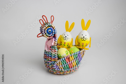 A colorful wicker basket in the shape of a chicken with eggs and ears. The concept is the Orthodox holiday of Bright Easter.