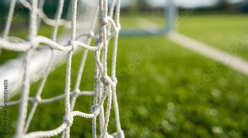 Close up of football goal net with blurred field background creating clean sport texture.
