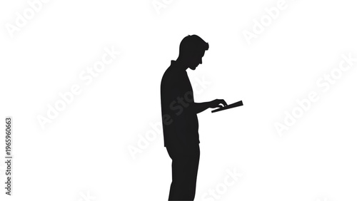 Silhouette of a man standing and using a tablet