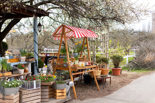 Wallpaper Mural Cozy outdoor garden shop with blooming plants in pots and seasonal holiday display. Easter exterior market stall with spring flowers, wicker baskets, bunny shaped candles, and festive decorations. Torontodigital.ca