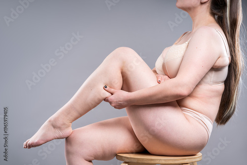 Woman in lingerie massaging calf muscle. Concept of leg pain, muscles cramp, edema or tired legs