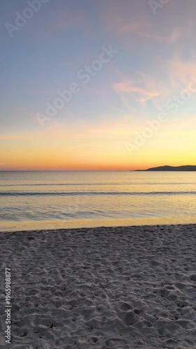 Vertical panoramic view of Maria Pia beach in Sardinia at sunset with golden light calm sea and mediterranean coastal landscape