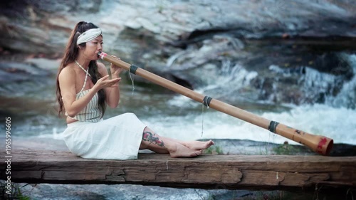 A Tranquil Performance by the Water: Woman Playing a Long Bamboo Instrument didgeridoo in a Scenic Natural Setting, Capturing the Essence of Music and Nature in Harmony