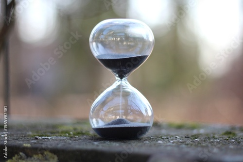 Hourglass on the stone surface concept of passing time hurry up live bein time 