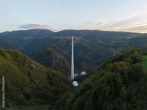 This aerial view shows a tall industrial chimney at a former coal plant site in Trbovlje, marking the shift from fossil fuels to renewables.