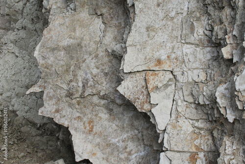 Peeling rock layers texture with cracks and weathered surface natural background