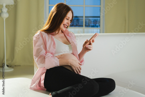 Pregnancy motherhood. Pregnant woman with smartphone typing scrolling at home. Woman with cell phone enjoying pregnancy surfing internet using social media apps. Mobile application for pregnant women