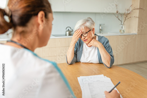 Female doctor examining older senior woman in doctor office or at home. Old woman lady patient and doctor have consultation in hospital room. Medicine healthcare medical checkup. Visit to doctor