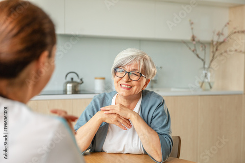 Female doctor examining older senior woman in doctor office or at home. Old woman lady patient and doctor have consultation in hospital room. Medicine healthcare medical checkup. Visit to doctor