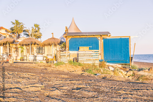 Beach huts and chiringuito bar on sandy mediterranean shore