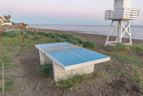 Outdoor ping pong table on beach at sunrise