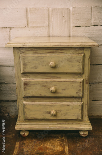 Fotografi Weathered vintage wooden nightstand with rustic drawers
