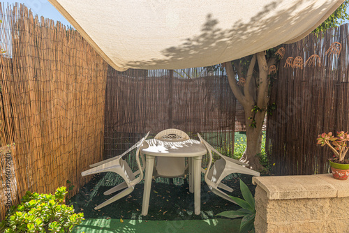 Patio table chairs under sunshade for outdoor relaxation
