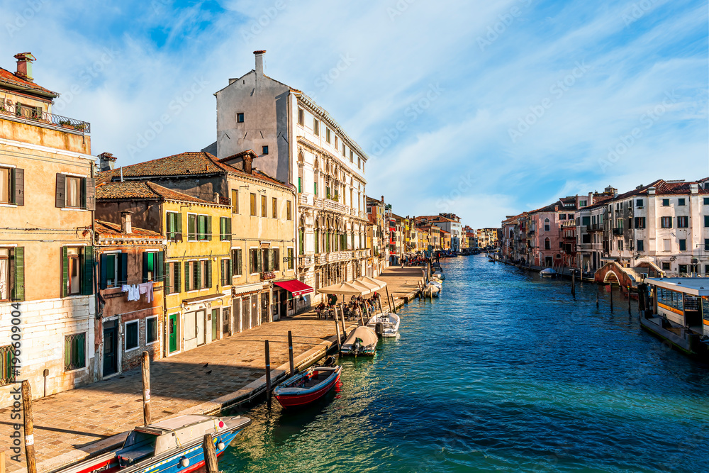 Obraz premium city of Venice with beautiful old buildings near embarkment of a canal wirh boats and water and beautiful cloudy sky on background