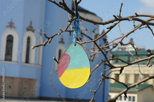 Painted Easter eggs on the branches of a tree in the city.