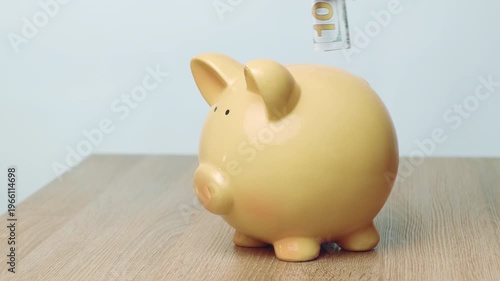 Hand Placing Bill Into Piggy Bank On Wooden Table, Closeup Of Beige Ceramic Piggy Bank As Walletsized Banknote
