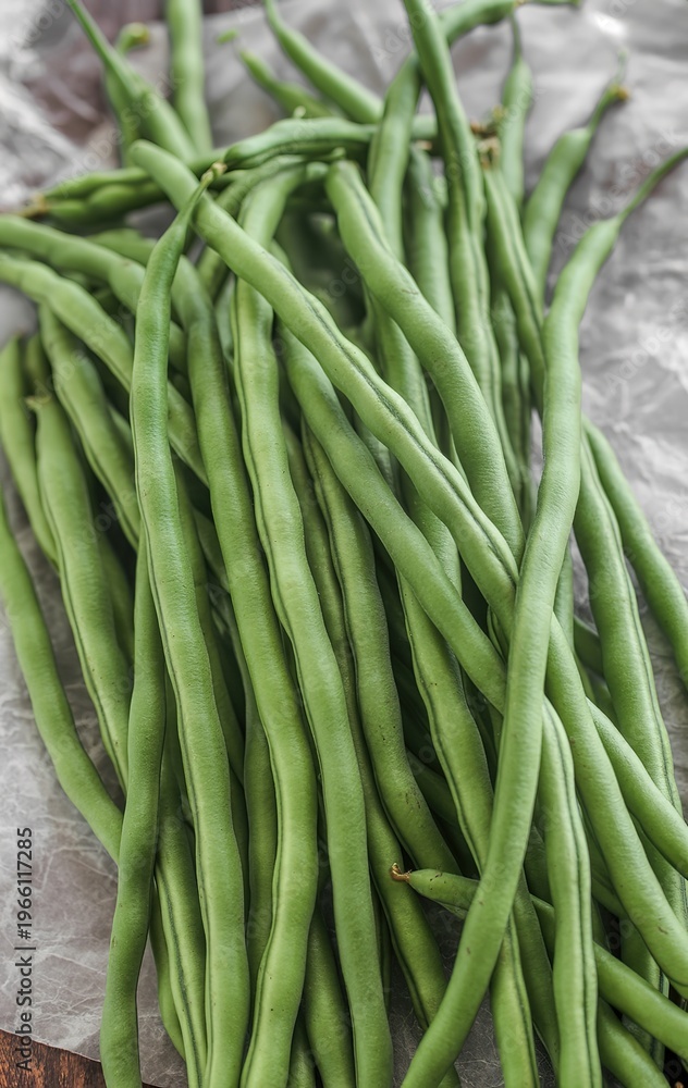 Obraz premium A Large Bunch of Long Green Snap Beans Placed on a Crumpled Paper