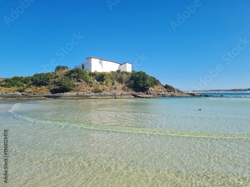 Photos Praia do Forte in Cabo Frio: crystal-clear beach, blue sky, sunny day, with the historic Fort São Mateus on the hill by the water