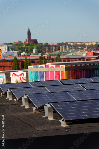 Solar panels on roof of apartment housing building with Gothenburg city center in background, Sweden, renewable green sustainable energy concept