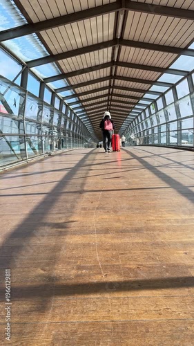 Young woman walking through airport with suitcase