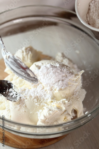 Adding powdered sugar into bowl with Ricotta and Mascarpone. Making frozen strawberry cheesecake series.