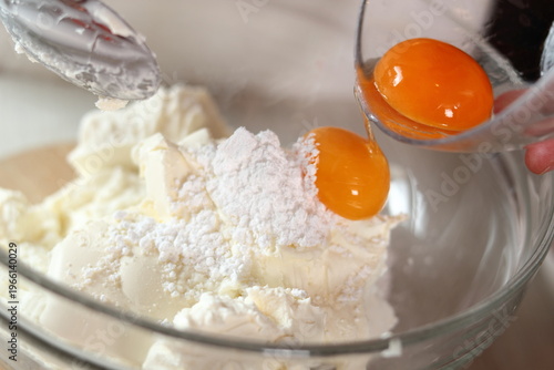 Adding egg yolks into cheese filling. Making frozen strawberry cheesecake series.