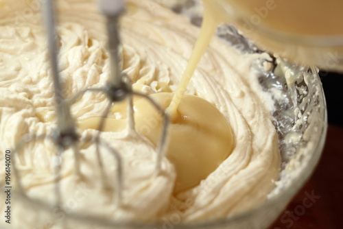 Pouring white chocolate and butter mixture into cheese filling. Making frozen strawberry cheesecake series.