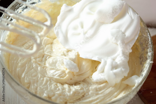 Adding whipped egg whites into cheese filling. Making frozen strawberry cheesecake series.