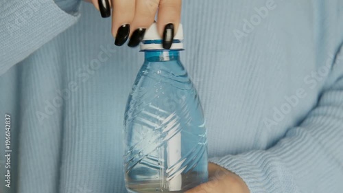 Female hands opening a bottle of water