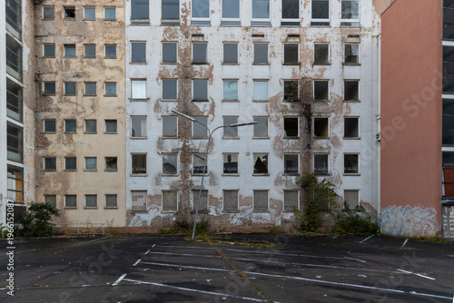 Verfallene Wohngebäude mit verwitterter Fassade und leerem Parkplatz in Frankfurt am Main Westend Süd