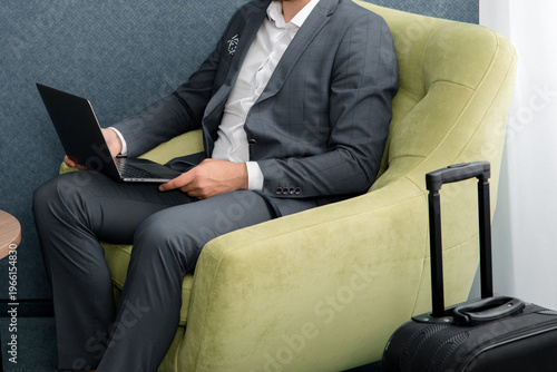 Young businessman is using laptop while sitting in the business lounge in airport