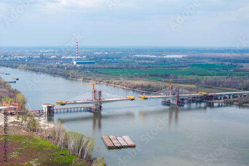 Large-scale construction of a modern cable-stayed bridge with tall tower cranes over a wide river