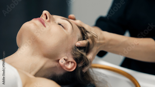 Young woman enjoying premium Japanese head spa in modern wellness salon. Relaxation and beauty concept.
