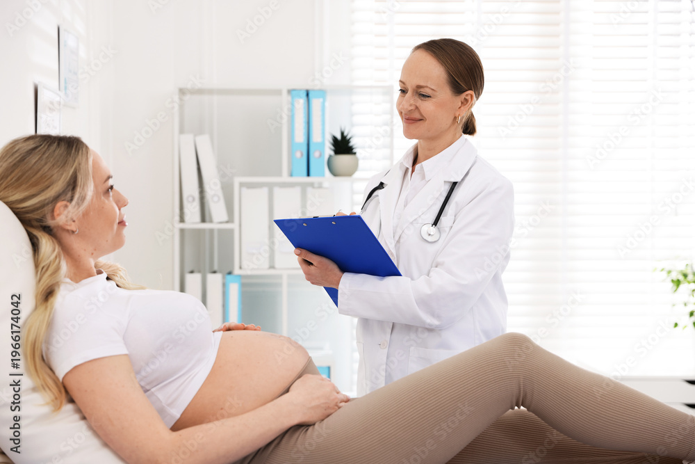 Fototapeta premium Pregnant woman having appointment with doctor in clinic