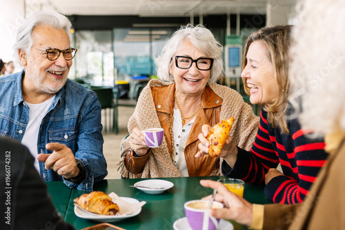 Fotografia Group of diverse senior friends sharing a happy breakfast moment at a cafe, drin