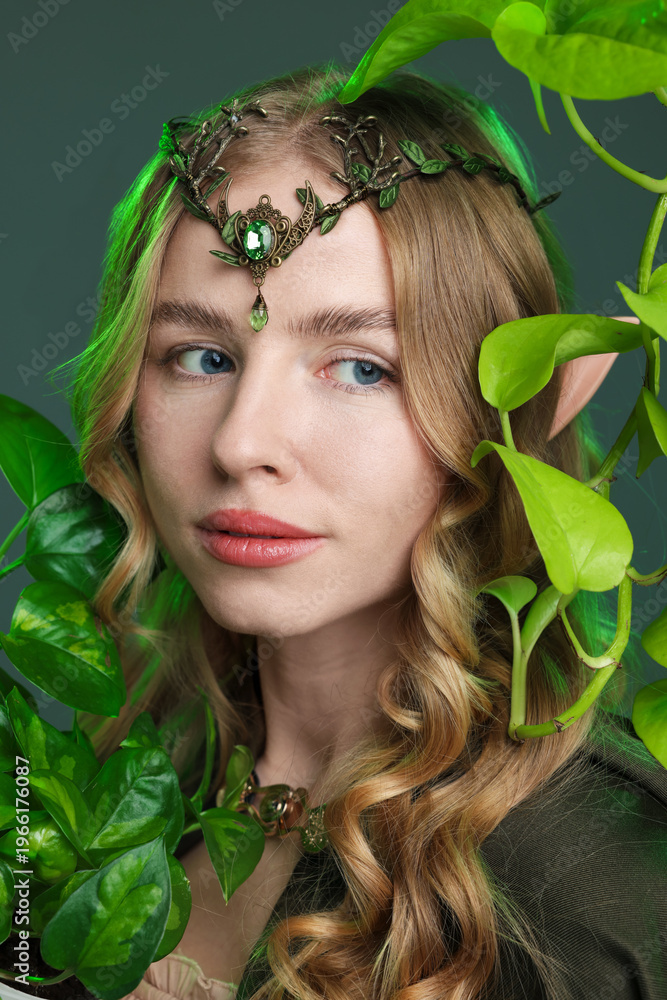 Obraz premium Beautiful elf girl and green leaves on grey background
