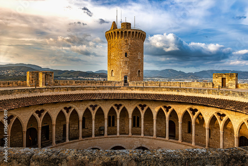 Vista panorámica del patio gótico circular del Castillo de Bellver bajo luz dorada del atardecer