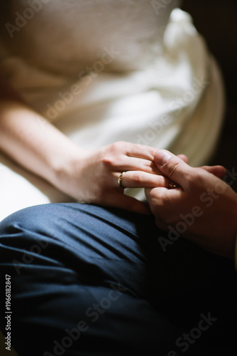 Close-up of hands with wedding rings, intimate moment between couple