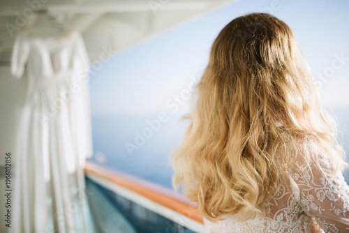 Woman with long hair gazes at ocean view from cruise ship balcony