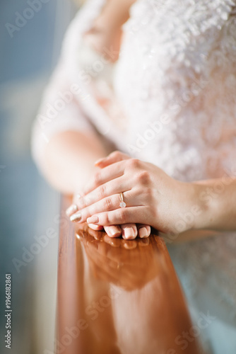 Close-up of woman's hands resting on polished wooden railing