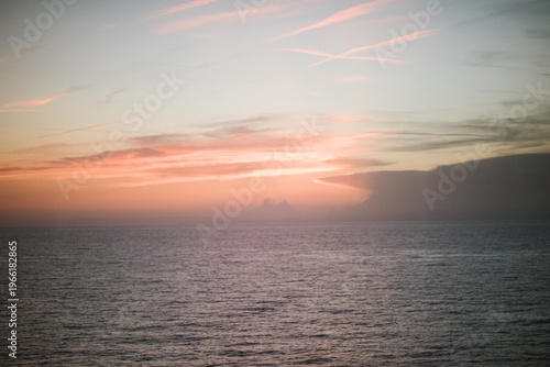 Serene ocean view at sunset with colorful sky and distant islands