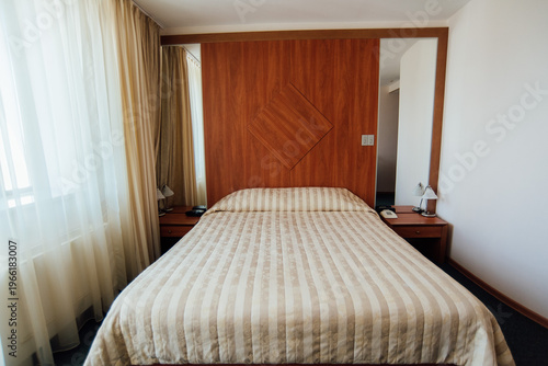 Astrakhan, Russia - September 18, 2015: Modern hotel room with striped bed and wooden accents