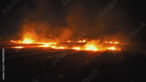 Heavy smoke from wheat field fire at night. Dry land after harvest burns fast. Air pollution and environmental damage. Climate impact concept.