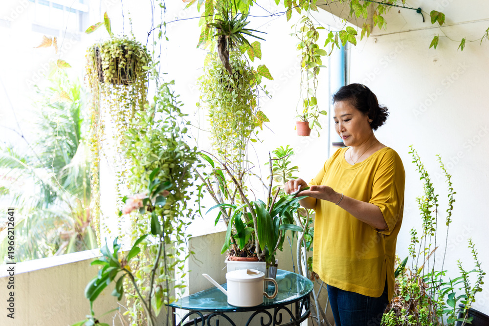 Fototapeta premium Woman tending plants on balcony.
