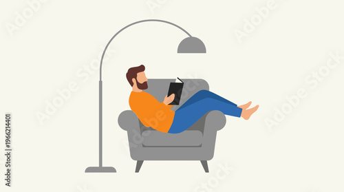A bearded man in an orange shirt and blue pants relaxing in a grey armchair, reading a book under a floor lamp.