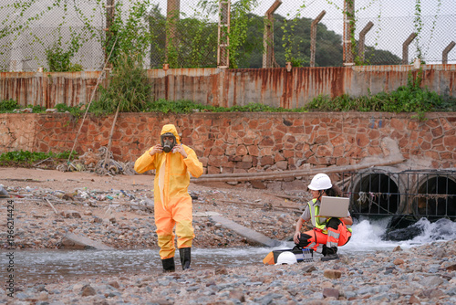 Cuadro en lienzo Environmental field team in protective gear analyzes water samples on a polluted beach
