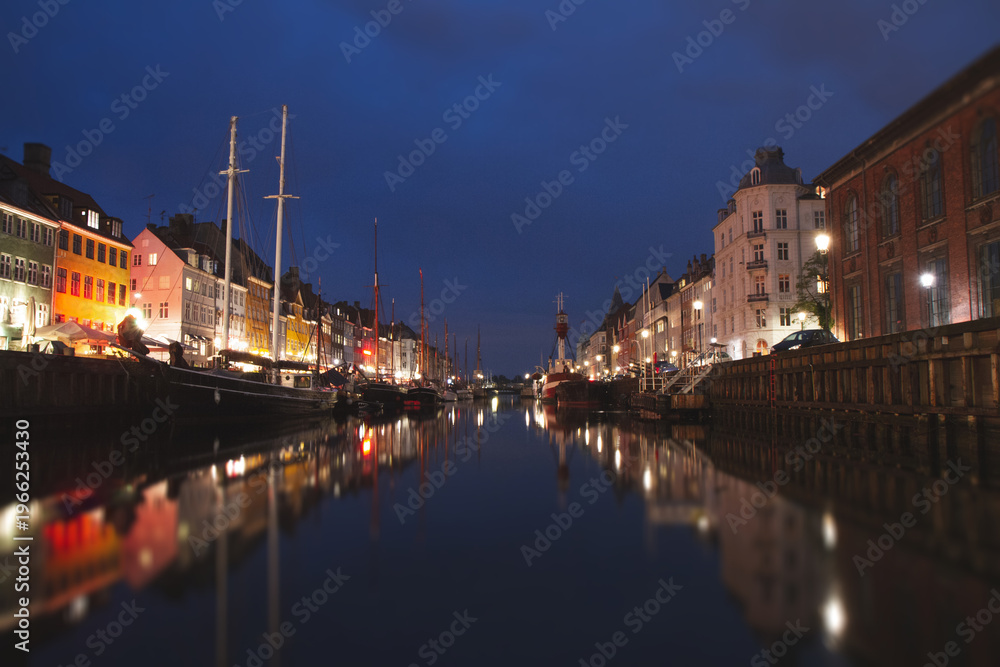 Fototapeta premium Night view of Nyhavn canal with lights and reflections in Copenhagen