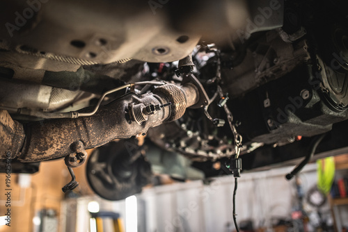Photos Close-up view of a car's exhaust system undergoing repair and maintenance